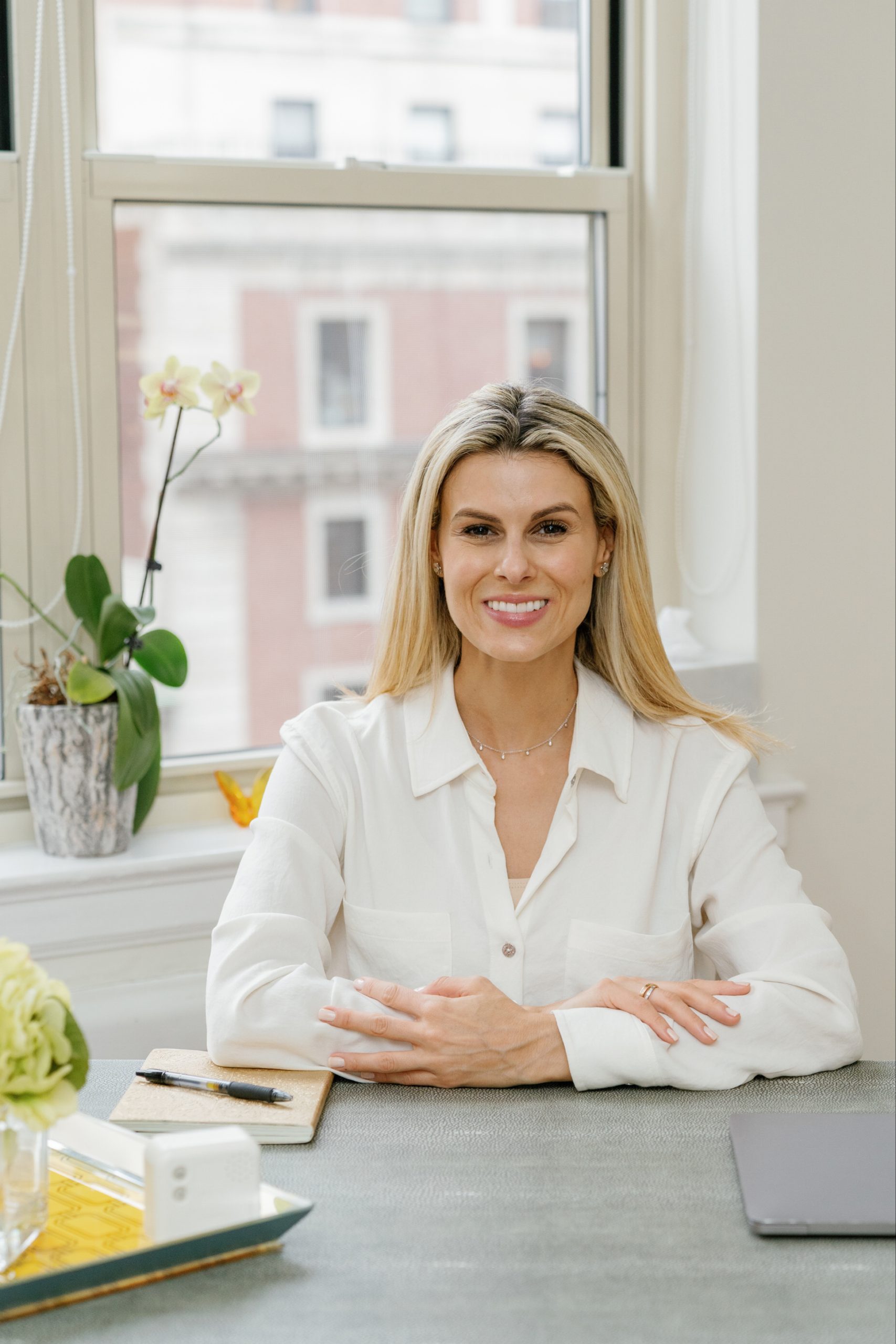 Amber Weiss seated at her desk beside a bright office window